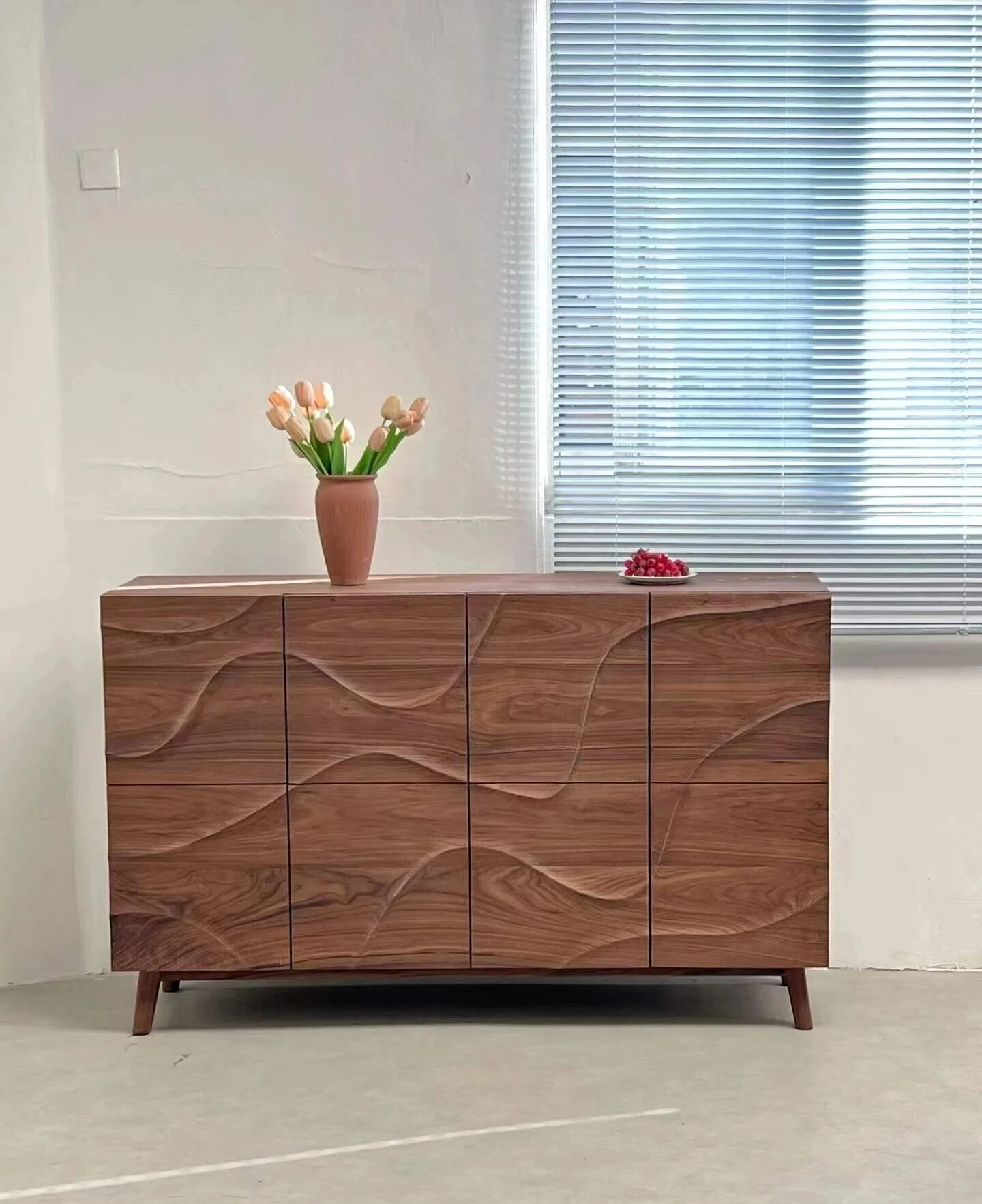 Black walnut sideboard with sculpted doors and continuous natural grain